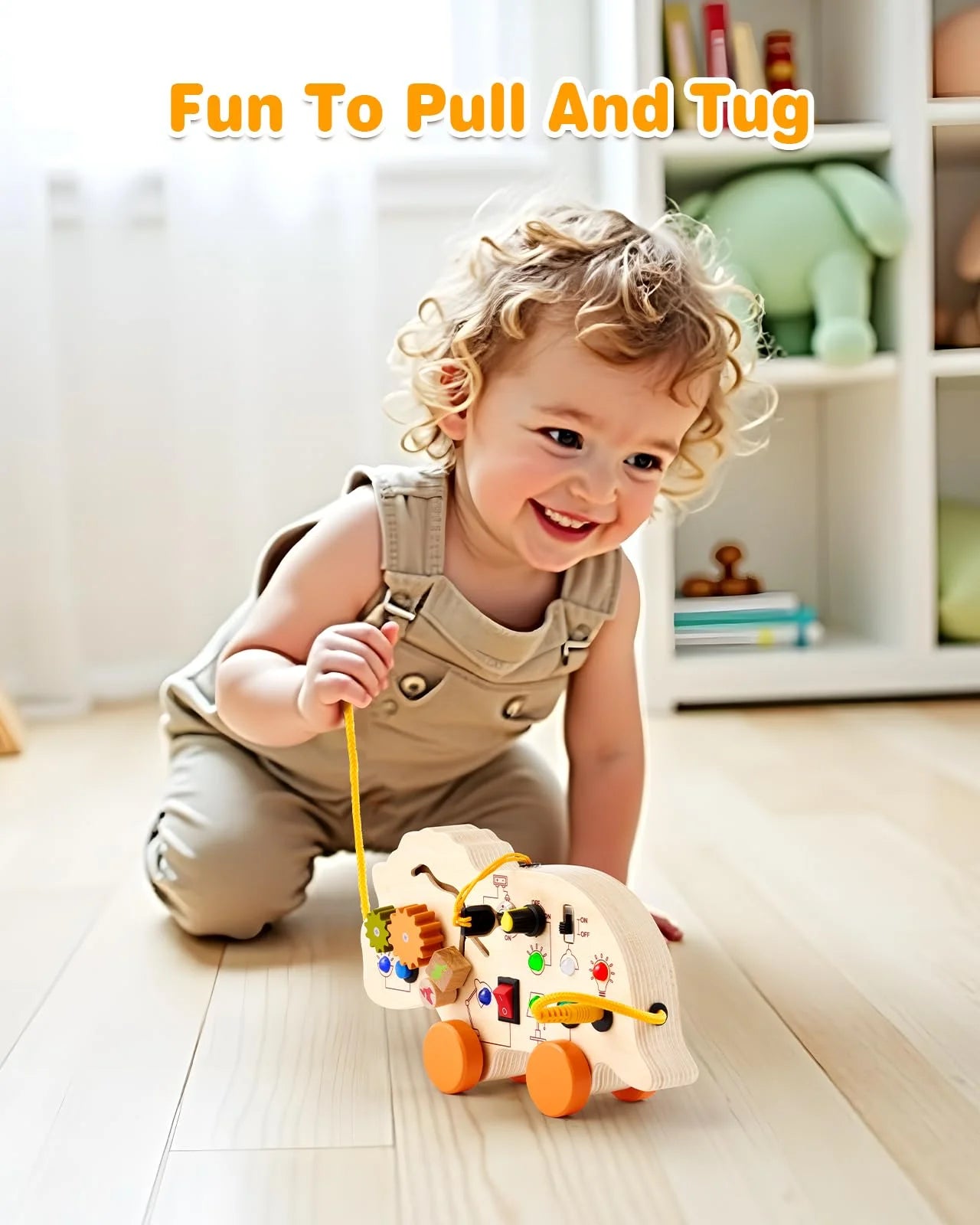 A happy toddler crawling on the floor while pulling a gleamkid wooden dinosaur busy board