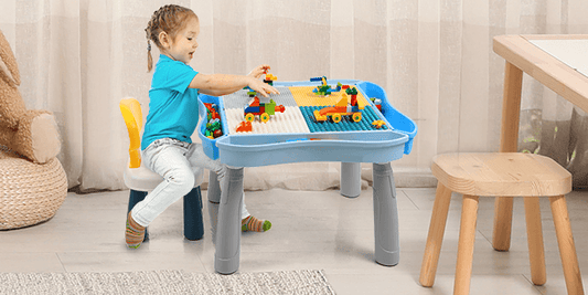 A girl happily using the Kids Activity Table and Chair Set with 320Pcs Building Blocks for creative play.