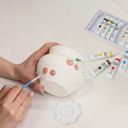 The 12 bright acrylic paints included in the pottery starter kit, which provide strong, waterproof coverage.